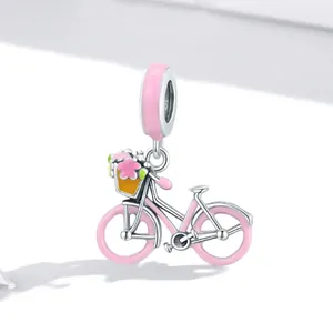 Gros plan d'un pendentif vélo en acier titane rose orné d'un panier de fleurs colorées