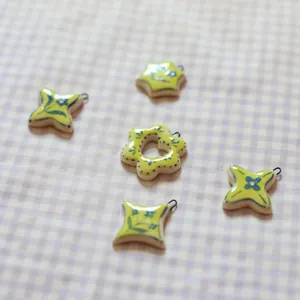 Detail view of five ceramic floral pendants with yellow glaze and blue patterns