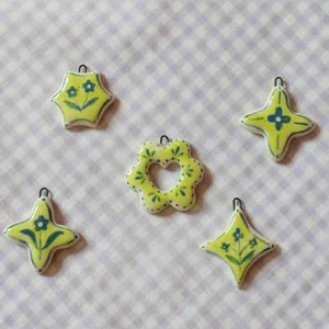 Detailed close-up showing five colorful ceramic pendants with floral star and heart patterns