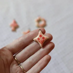 Close-up of a handmade floral star pendant in hand for a minimalist necklace