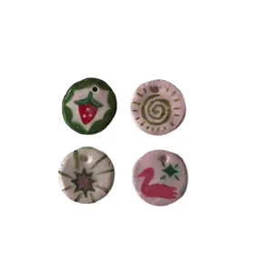 Set of four colorful handmade round clay pendants with strawberry and swan motifs for jewelry DIY