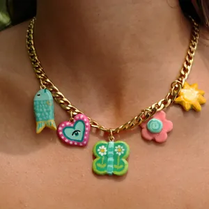 Detailed view of a gold-tone chain necklace with colorful butterfly and heart charms.