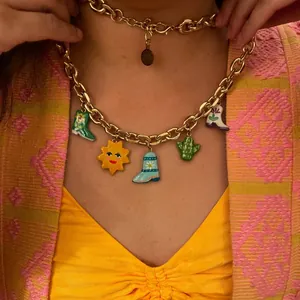 Dopamine style chunky gold chain necklace with colorful boot and sun charms on model