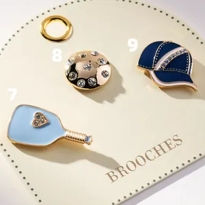 Detailed view of colorful enamel sports brooches including blue paddle and baseball cap
