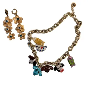 Vibrant gold-tone flower earrings paired with a multi-charm enamel animal necklace set