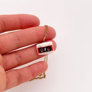 Gros plan détaillé d'un pendentif de cassette rétro colorée sur un collier doré élégant