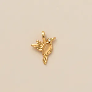 Nahaufnahme des goldenen Kolibri-Anhängers mit Edelstein und Kristallauge.