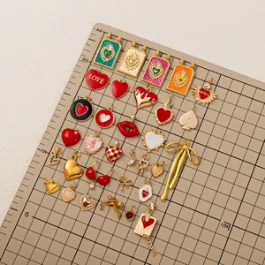 Gros plan de divers pendentifs en acier inoxydable en forme de cœur, nœud et tarot