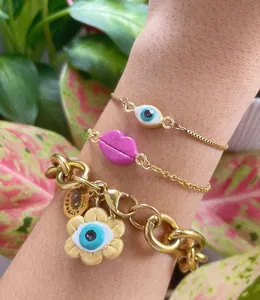 Makroaufnahme von bunten Dopamin-Edelstahl-Bettelarmbändern mit bösem Auge und Lippen-Design