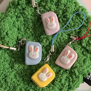 Colorful rabbit enamel pendants with stainless steel clasps on green texture