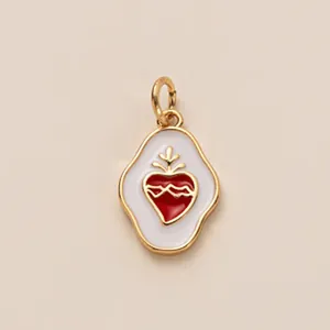 Gros plan d'un pendentif cœur en acier inoxydable doré avec émail rouge et blanc.