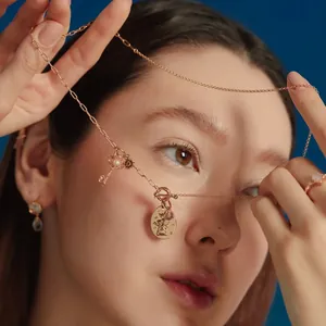 Close-up of a stainless steel necklace with various charms worn by an Asian model.