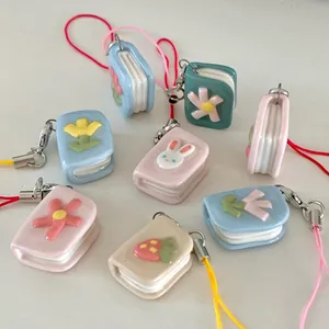 Detailed view of assorted miniature book charms with cute rabbit and flower motifs.