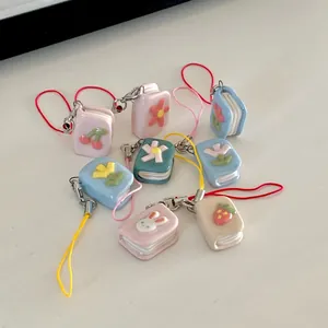 Detailed view of colorful enamel book charms with cute flower and animal patterns.