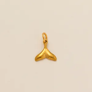 Nahaufnahme eines minimalistischen goldenen Walflossen-Anhängers aus Edelstahl für Ketten