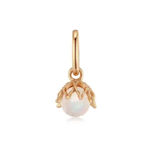 Close-up of elegant gold-plated stainless steel pendant with iridescent pearl and crown cap