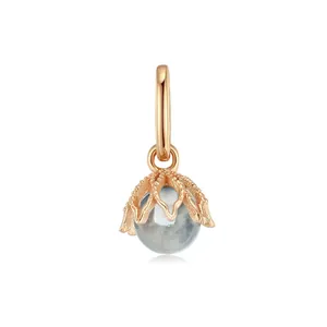 Macro detail of a rose gold stainless steel pendant with a light blue birthstone bead