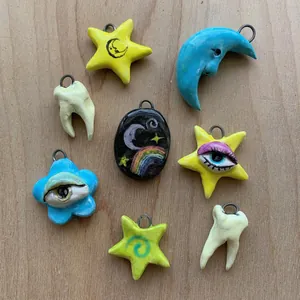 Dettaglio ravvicinato di pendenti colorati fatti a mano a forma di stella e luna a goccia