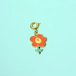 Close-up of a colorful enamel flower pendant with a smiley face center and gold clasp