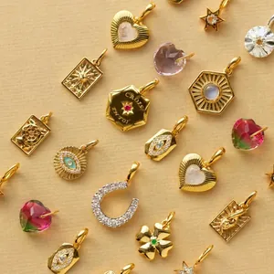 Collection of various gold-plated stainless steel pendants featuring evil eye and heart designs