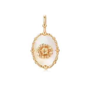 Detailed view of oval gold pendant with mother of pearl and central zircon flower