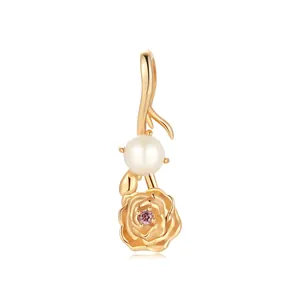 Macro view of gold stainless steel flower pendant with white pearl and pink zircon