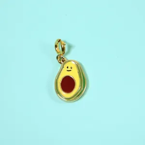 Close-up of cute avocado enamel pendant with a smiley face on a blue background