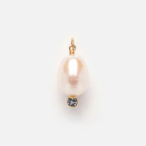 Detailed close-up view of an elegant white oval pearl pendant with a blue gemstone