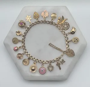 Dettaglio di un bracciale con ciondoli dorati con occhio greco, cuori e stelle