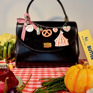Vue détaillée de breloques colorées en forme d'aliments sur un sac à main élégant