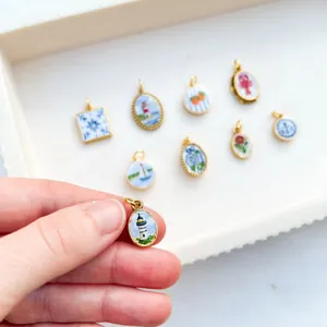 Detailed macro view of gold plated stainless steel lighthouse pendant and charms