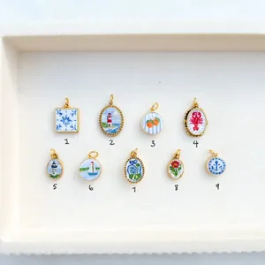 Detailed view of nine colorful enamel stainless steel pendants with various nautical and floral motifs