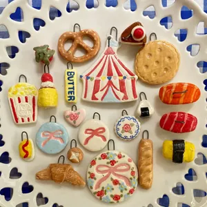 Une variété de breloques en émail colorées présentées sur une assiette blanche décorative