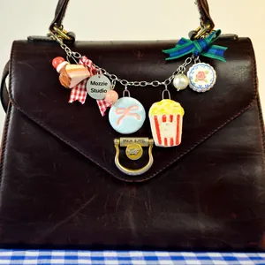 Détail d'un bijou de sac sur le thème alimentaire avec pop-corn et gâteau en acier