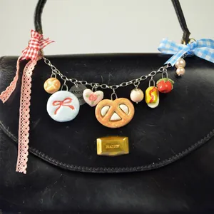 Détail d'un bijou de sac coloré thème nourriture avec pendentifs bretzel et cœur