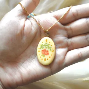 Detailansicht eines vintage ovalen Rosenanhängers an einer goldenen Edelstahlkette