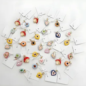 Detalle de colgantes de dopamina coloridos con diseños variados de hongos y corazones