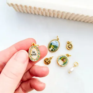 Nahaufnahme eines Vintage-Anhängers aus Edelstahl mit dem Text 'be still' und Blumenrand