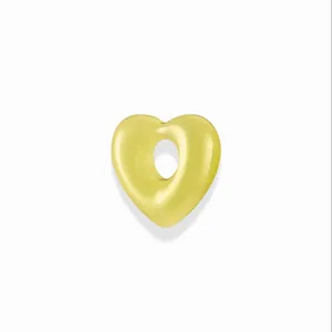 Macro-detail van een gele hartvormige hanger met gat in het midden voor DIY-sieraden