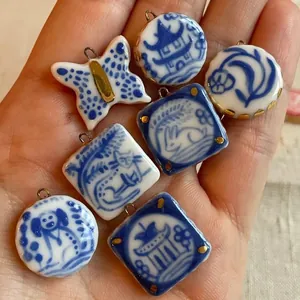 Detailansicht von blau-weißen Kerantikanhängern mit handgemalten Tier- und Pagodenmotiven.