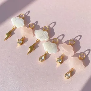 Detailed view of cloud charms with lightning, star, and teardrop pendants in 18k gold.