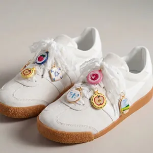 Detailed view of colorful fruit and flower print DIY shoe charms on white sneakers