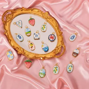 Assortiment de breloques DIY imprimées d'été avec cadres dorés sur satin rose élégant