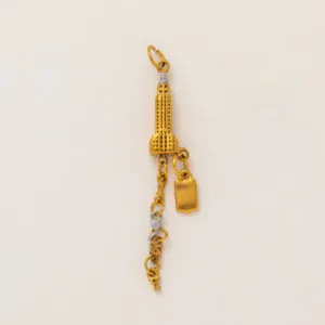Macro detail of a golden Empire State Building charm with tiny NY initial pendants