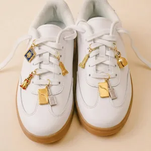 Detailed close-up showing various DIY metal jewelry charms attached to sneaker laces
