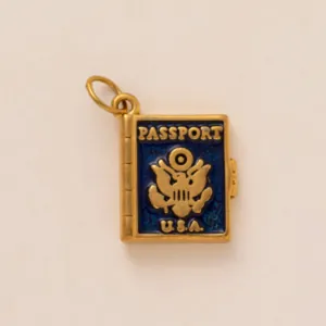 Detailed view of a miniature U.S.A. passport charm with blue enamel and gold finish