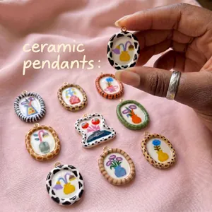 Close-up of hand-painted ceramic pendants with animal prints and floral designs