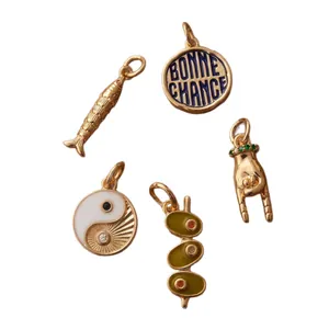 Assorted gold DIY jewelry charms featuring Yin Yang, fish, and hand gesture pendants