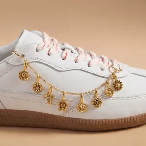 Nahaufnahme einer vergoldeten 18 Karat Blumen-Charm-Kette für Turnschuhe aus Edelstahl