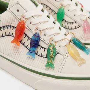 Dettaglio di vivaci ciondoli colorati a forma di pesce per scarpe da ginnastica